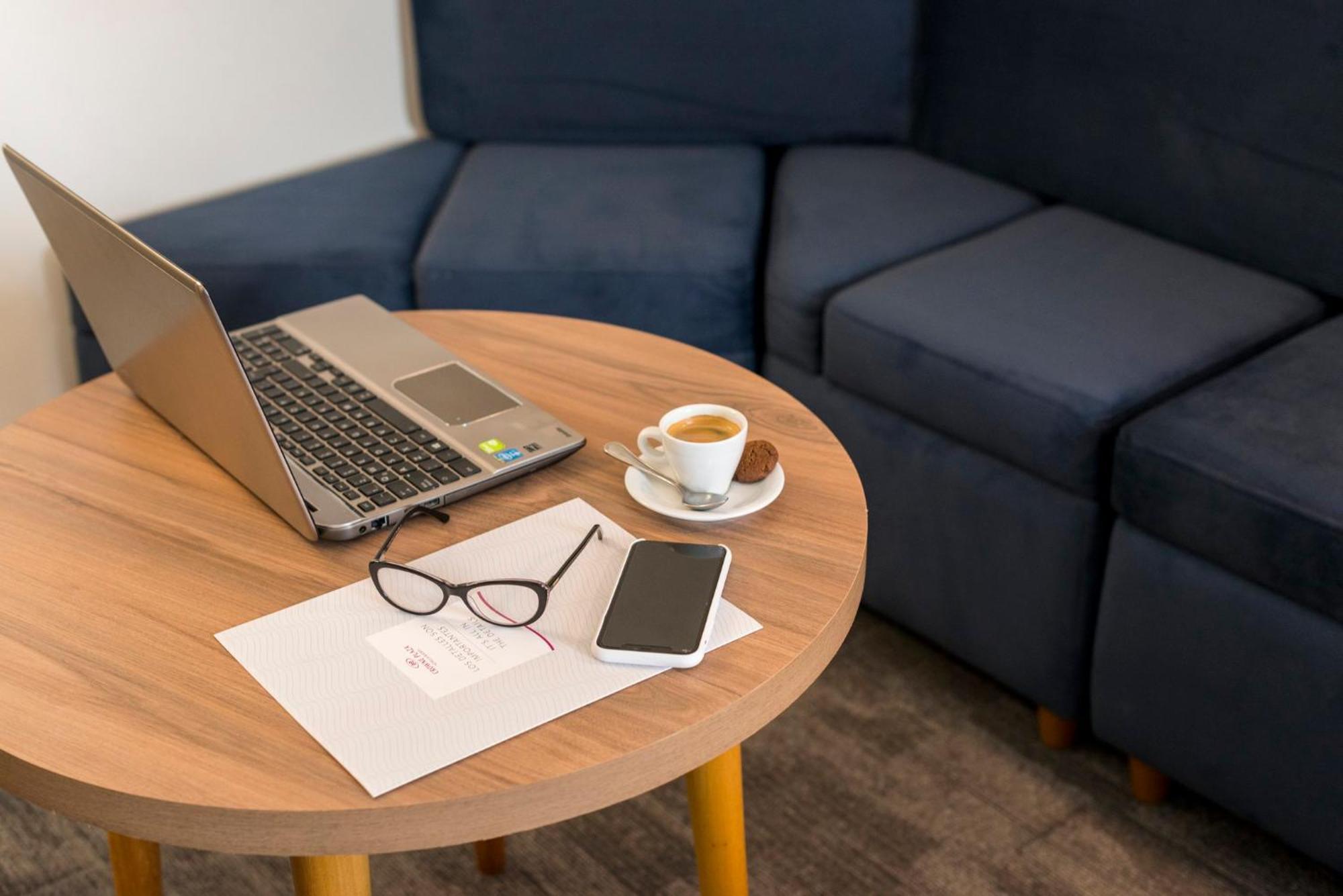 Отель Crowne Plaza Lima By Ihg Экстерьер фото A coffee table with a laptop, a cup of coffee, a mobile phone, and a pair of glasses